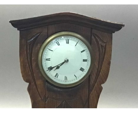 ARTS &amp; CRAFTS OAK MANTEL CLOCK LATE 19TH CENTURY the white enamel dial set with Roman numerals, the carved balloon-shaped