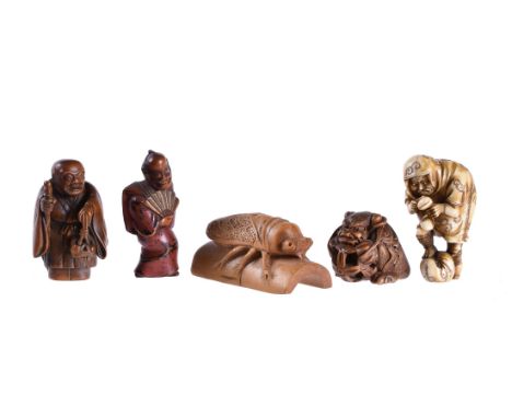 ϒ Sato Masayoshi: A Wood Netsuke of a Shishi sitting on its haunches as it grips a brocade ball between its forepaws and appe