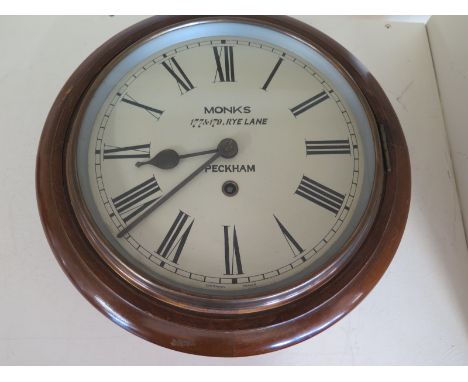 A wall clock by Monks 177 & 179 Rye Lane, Peckham - Roman Numerals on white enamel dial