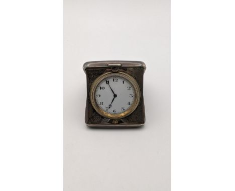 An early 20th century silver cased travel clock engraved with inscription, having a white enamel dial Location: 