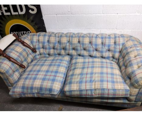 A late 19th/early 20th century upholstered Chesterfield, the button upholstery in a red, cream, blue and white check pattern,