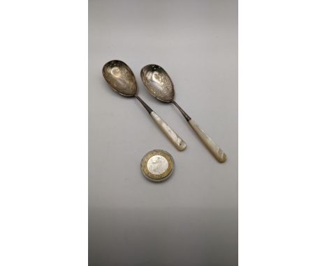 A pair of silver and mother of pearl fruit spoons having floral engraved detail, together with a 999 sterling silver HS Luxur