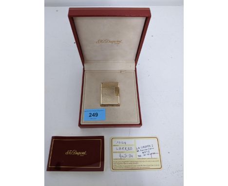 An S J Dupont gold plated cigarette lighter, serial number L 3EK80, boxed with information leaflet and guarantee Location: 