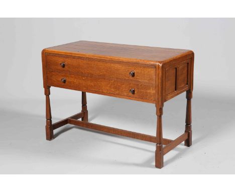 A COTSWOLD STYLE OAK CHEST OF DRAWERS, the four-plank top within a surround with rounded edge, over two long drawers with tur