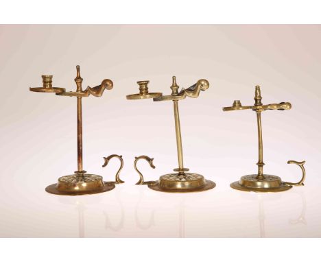 THREE GEORGE III BRASS WAX JACKS, circa 1775, each of characteristic form with urn finial, divided scissor plate, plain stem 