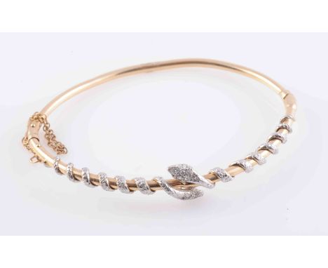 A LATE VICTORIAN DIAMOND SET BANGLE, set to the top section with two snakes, the bodies with engraved detailing twisted round