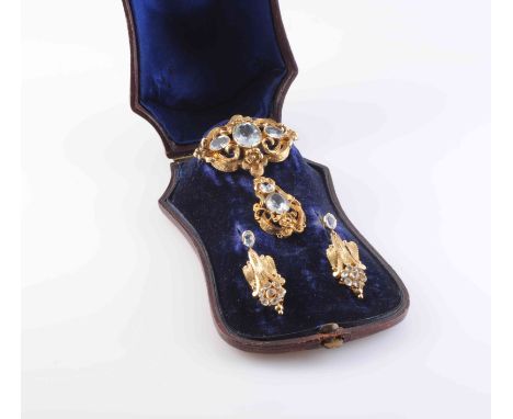 AN EARLY VICTORIAN AQUAMARINE AND GILT METAL BROOCH, the two graduating oval cut aquamarines set within a surround of elabora