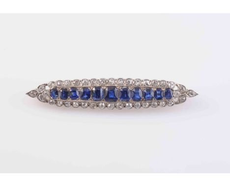 A FINE EDWARDIAN NATURAL SAPPHIRE AND DIAMOND BROOCH, the tapering navette brooch set to the centre with eleven graduating em