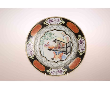 A CHINESE EXPORT PLATE, enamel painted with a lady playing a zither in an interior within a shaped cartouche with black and g