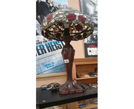 A tall table lamp with Tiffany style glass shade