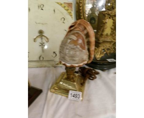 A carved cameo shell table lamp with brass base