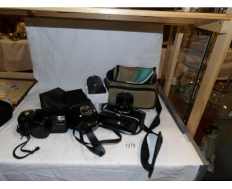 A Canon AE1 camera, A Canon megazoom 105 camera, a lens and a flash unit