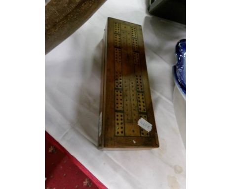 A box with cribbage board top containing dominoes and draughts