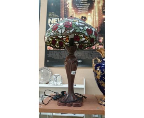 A tall table lamp with Tiffany style glass shade