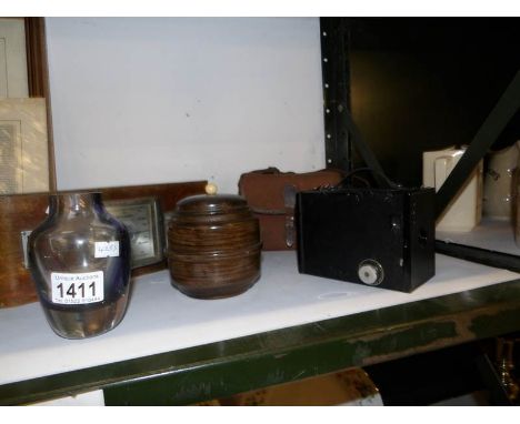 A thermometer/barometer, box brownie camera, tobacco jar and vase