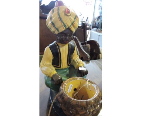 An early 20th Century plaster table lamp modelled in the form of a snake charmer, H:31cm