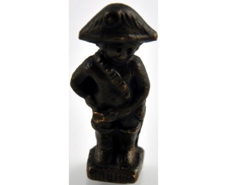 A small brass pipe tamper in the form of an 18th century cavalry officer, H. 4.5cm.