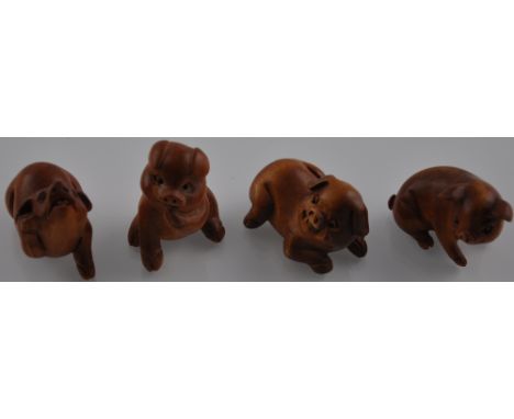Four hardwood netsuke carvings modelled as pigs