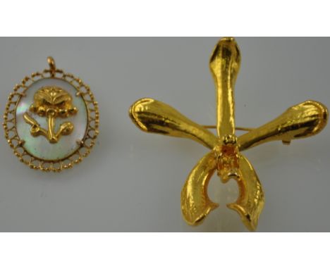 A yellow metal and mother-of-pearl pendant, oval framed and set with a flower, 5.3g. and a gilt metal floral brooch, (2).