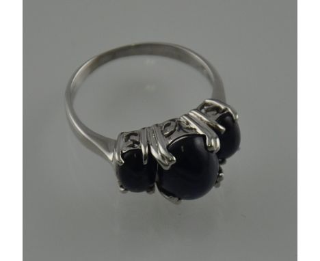 A blue three stone cabouchon ring clan set in a silver band.