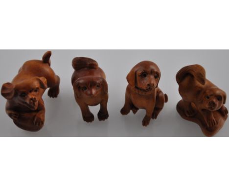 Four netsuke hardwood carvings, modelled as dogs