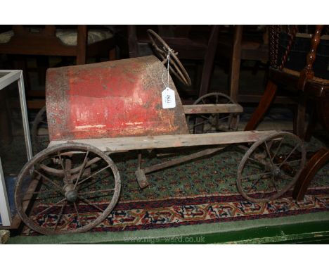 A vintage Pedal Car, red tin front, no seat, pre-war.