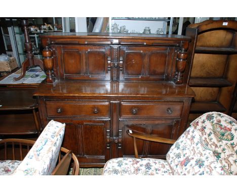 A Ercol (believed) dark-stained Court Cupboard style Sideboard having two frieze drawers with a double doored cupboard below.