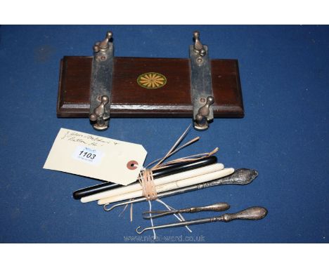 Three glove stretchers, three button hooks plus wooden tie press.