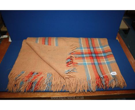 A fringed woolen Blanket in light brown with blue and red plaid to one side, with the reverse plain.