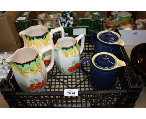 A set of three graduated vintage Wade Heath ceramic jugs with hand painted floral design; 6", 5 3/4" and 5 1/4" tall. Along w