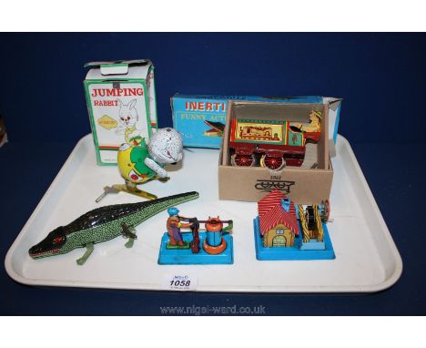 A box of vintage metal toys including a tractor, a crocodile and a jumping rabbit.