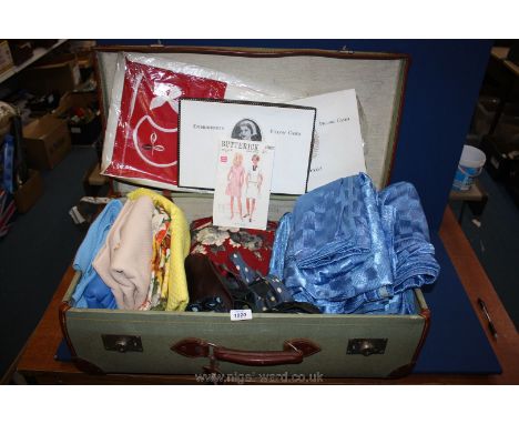 A suitcase containing vintage Curtains and fabric and two boxed pillowcases.