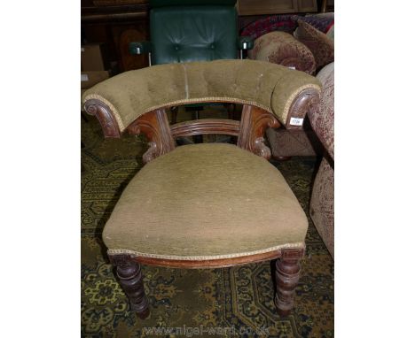 A late Victorian Oak framed bow-back elbow Chair having buttoned backrest and over-stuffed upholstered seat, standing on turn