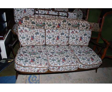 An Ercol stick-back 'Windsor' three-seater Settee with cushions upholstered in Sanderson's Hog Hunting landscape scene fabric