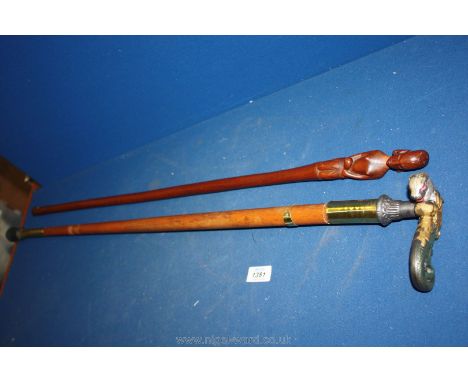 A wooden stick with native handle and a heavy stick having brass and a heavy mythical creature handle.