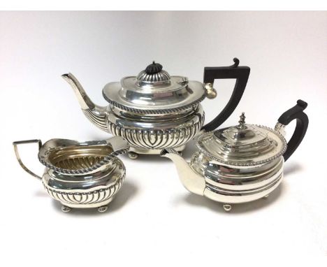 1920s silver teapot of half fluted form, with gadrooned border, angular Ebony handle and hinged domed cover, on four bun feet