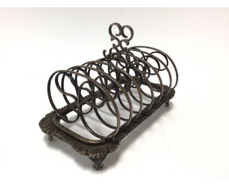 Edwardian silver six division toast rack of conventional form with gadrooned, shell and scroll borders and scroll handle, rai