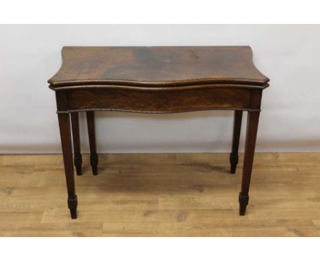 George III style mahogany serpentine card table, with fold over top enclosing baize playing surface raised on gaitered tapere