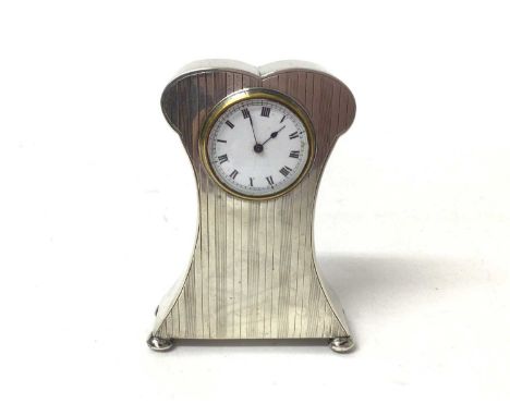 George V silver mounted dressing table clock in shaped case with reeded engine turned decoration, raised on bun feet, (Birmin