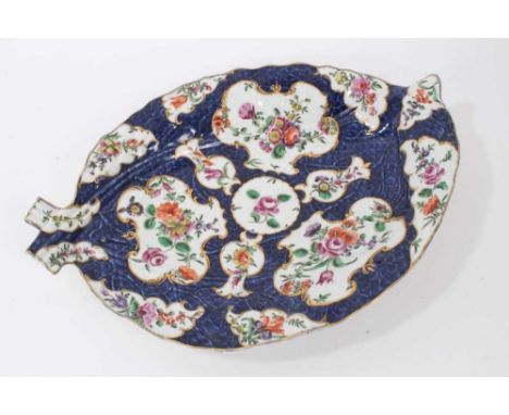 A Worcester cabbage leaf shaped dish, circa 1770, decorated with flowers on a blue scale ground, pseudo-Chinese mark to base,