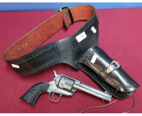 Tooled leather Western style gun holster belt with a replica model single Action Army .45 1874 revolver, with a small selecti