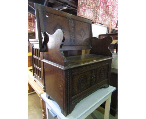 An Edwardian oak monks bench with box seat, carved fretwork and Tudor rose detail