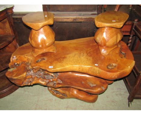 A most unusual occasional or centre table hewn as a single piece from a hardwood timber trunk, resulting in a complicated, ye