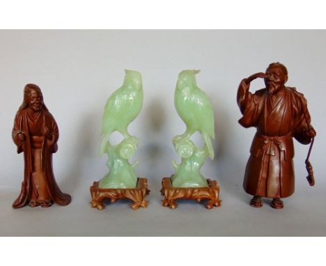 A pair of Chinese carved jade figures of parakeets on branches, upon original wooden plinth bases, 20cm high, together with a