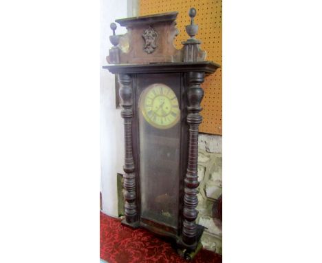 A Vienna type two train wall clock, the enamel dial with Roman numerals in a turned case, 110cm high