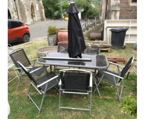 A contemporary coated light aluminium framed garden table of rectangular form with rounded corners and inset glass top raised