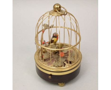 A vintage French singing bird music box fitted with a gilt cage and foliage, 17cm high (currently not working)