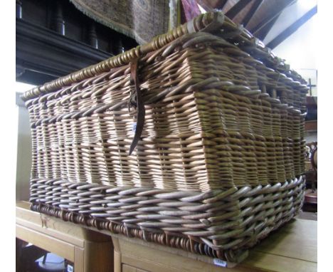 A wicker laundry basket/hamper with vellum/leather bindings and wooden sledge supports