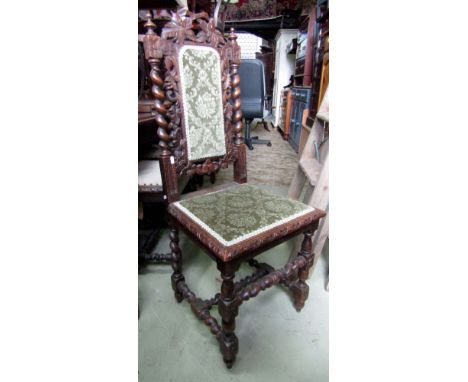 A pair of Victorian Gothic oak dining chairs with carved scrolling grape and vine detail raised on spiral twist and turned bo