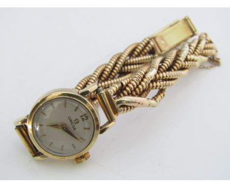 A vintage Omega 9ct ladies cocktail watch, with champagne dial and plaided 9ct strap, 29 grams gross